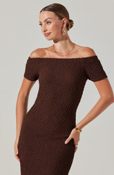 A woman wearing a fitted, textured brown off-the-shoulder dress with short sleeves.
